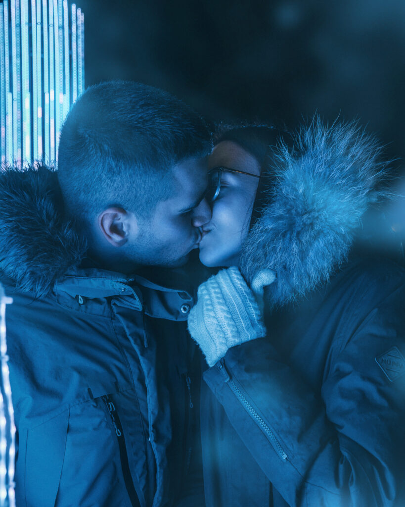 Noorpaar suudlemas Tallinnas Vabaduse Väljakul õhtutuledes - paarifoto